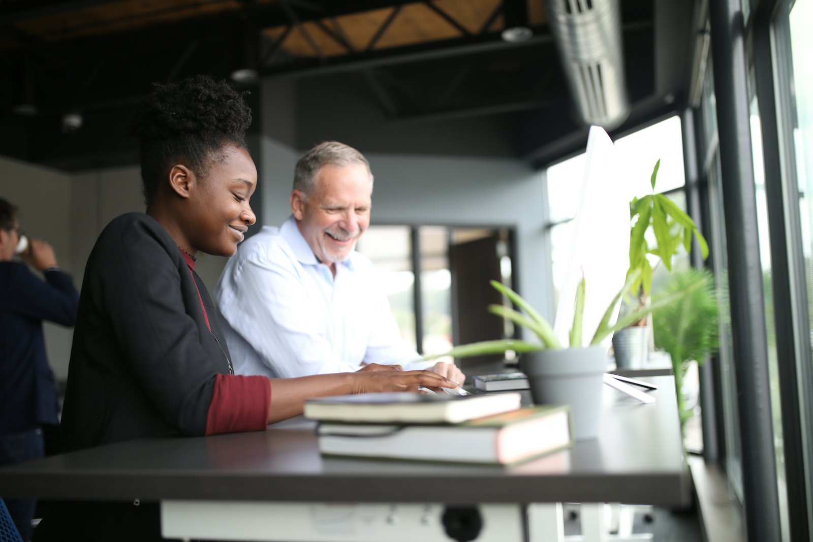 Two people working through a problem together at a desk