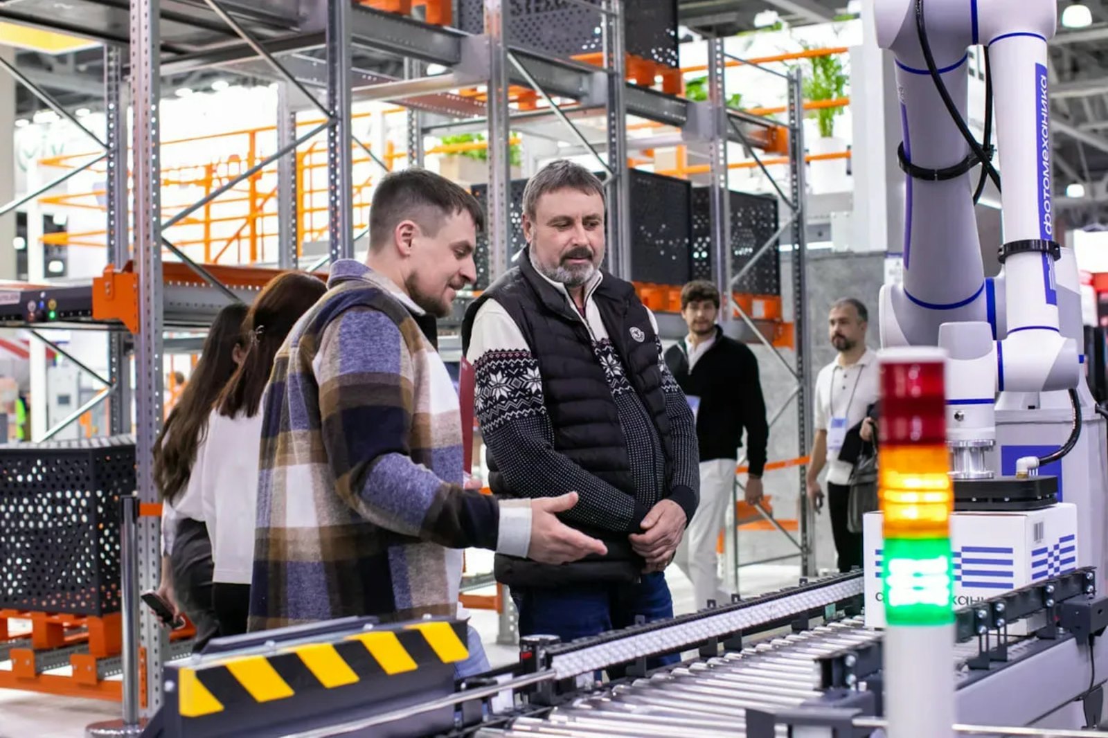Two people watching an automated conveyor in a warehouse