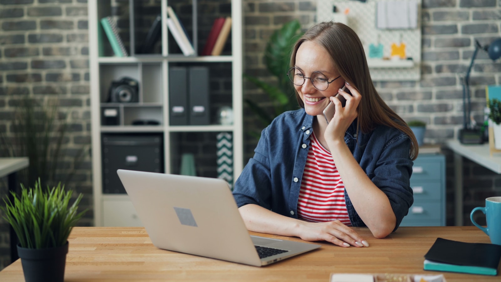 A woman on the phone at a laptop